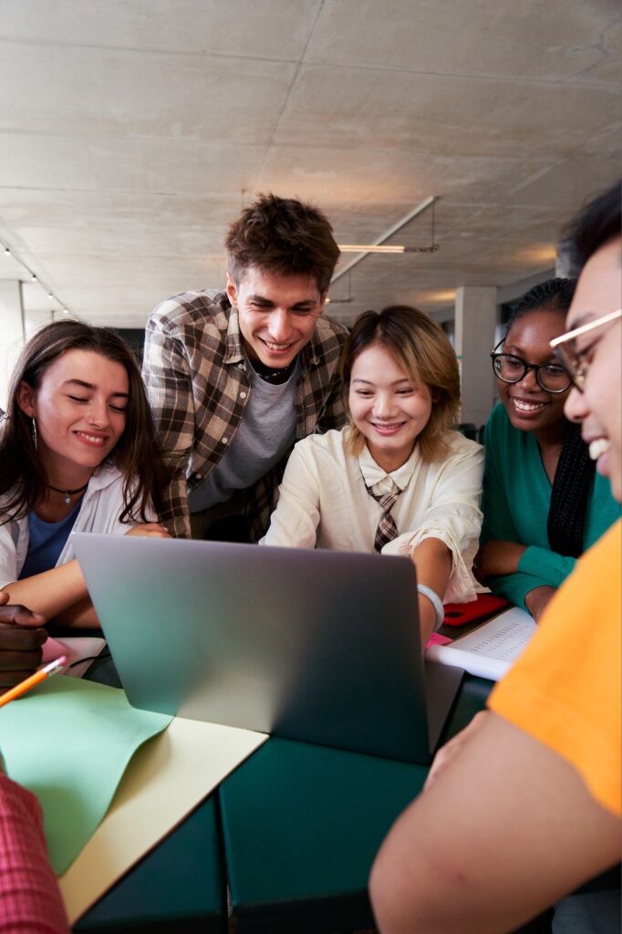 Multiracial group of university students sitting in the cafeteria studying together after classes.